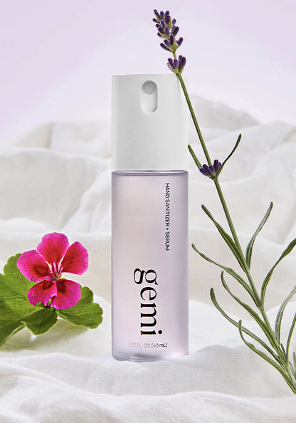 Gemi hand sanitizer bottle with lavender and geranium flower on a white background.